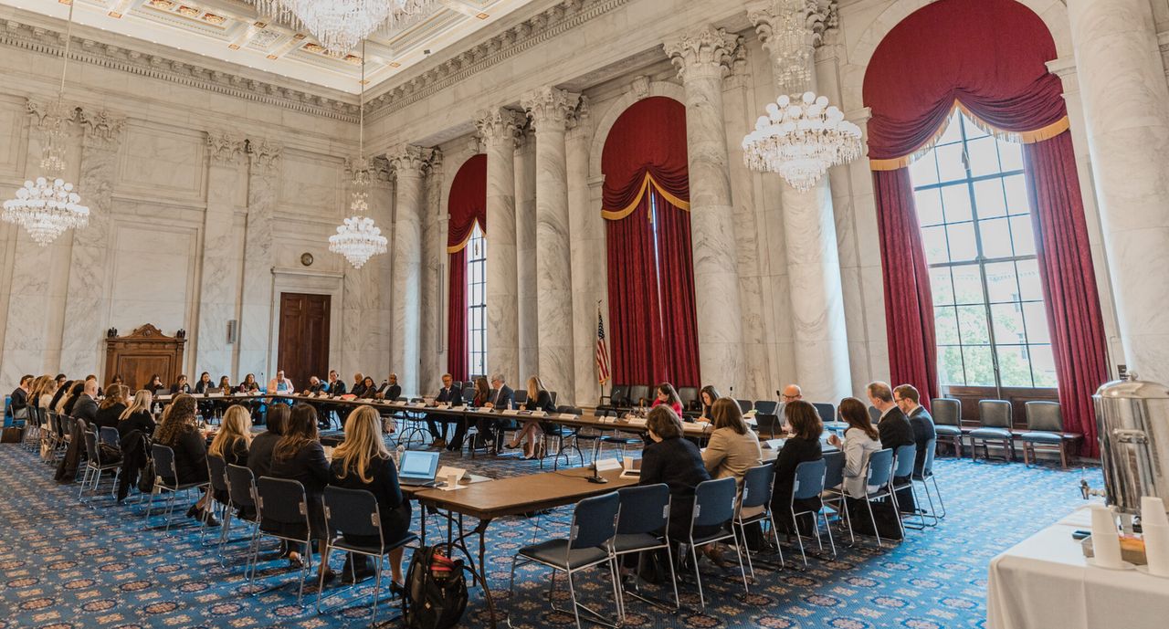 Formal government meeting around a U-shaped table